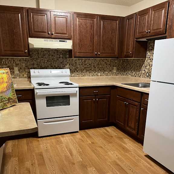 a kitchen with wooden cabinets and a white microwave.
