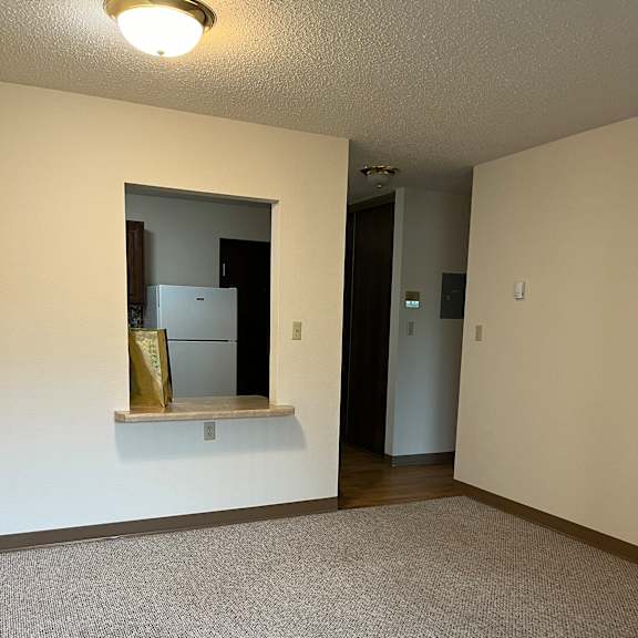 a small mirror on a wall reflects a cabinet and a shelf.