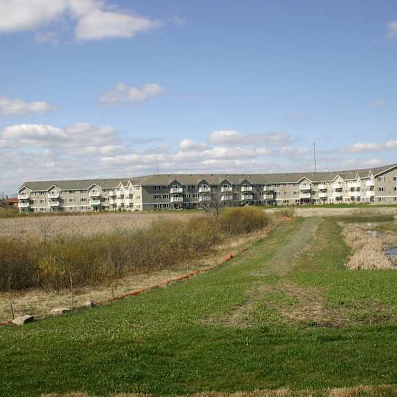 a large white building with a green lawn in front of it.