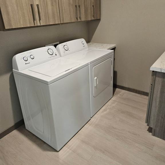 a white washing machine in a laundry room.
