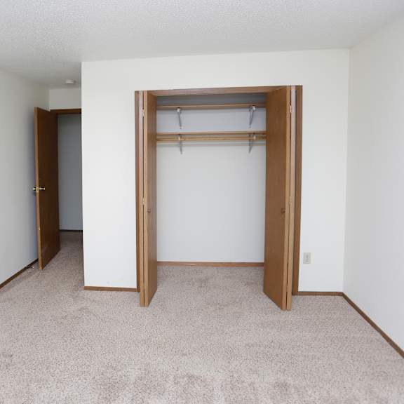 an empty room with a closet and a door to a bathroom