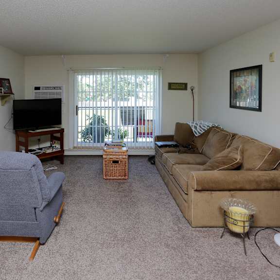 a living room with a couch and a chair and a television