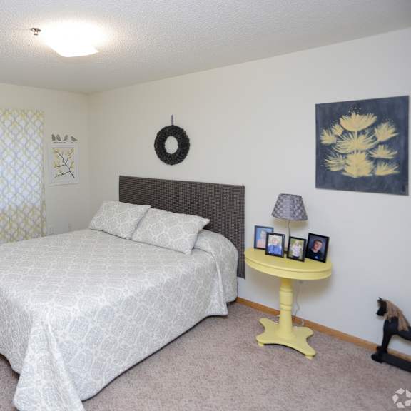a bedroom with a large bed and a yellow table