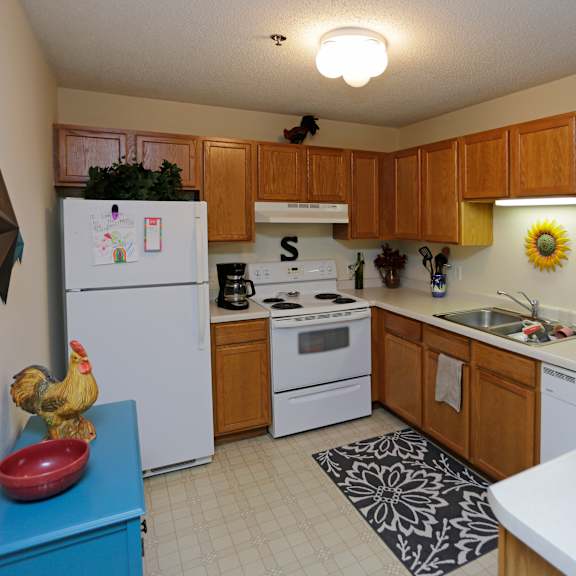 a kitchen with white appliances and wooden cabinets