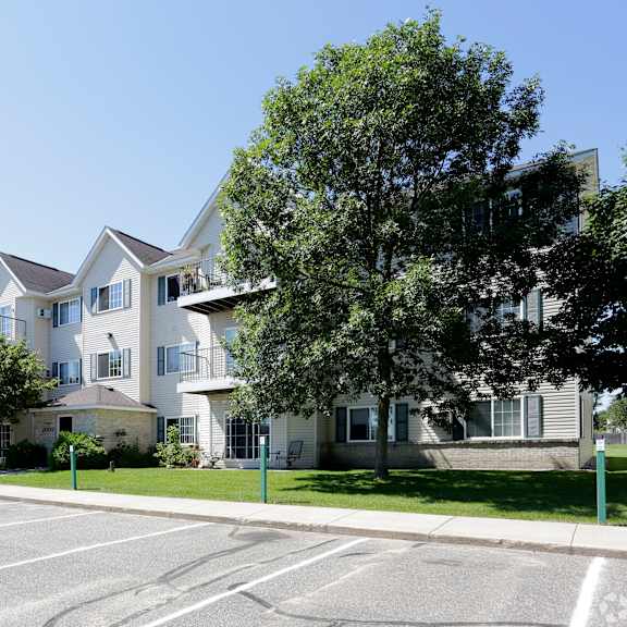 a row of houses with a parking lot and a car parked in front of it