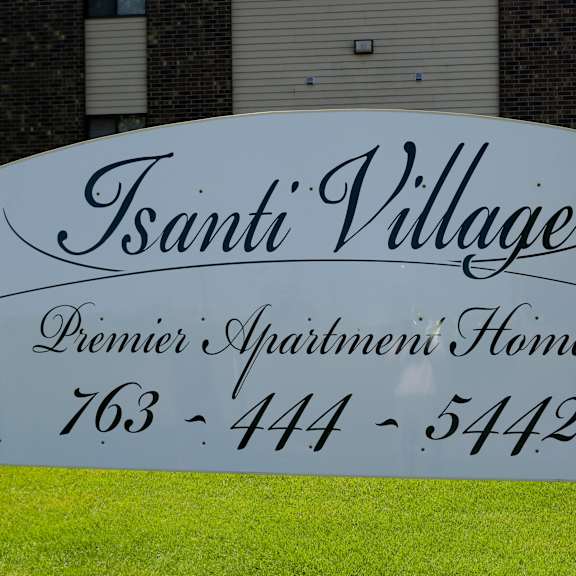 a white sign in front of a house with the name of a tenant village