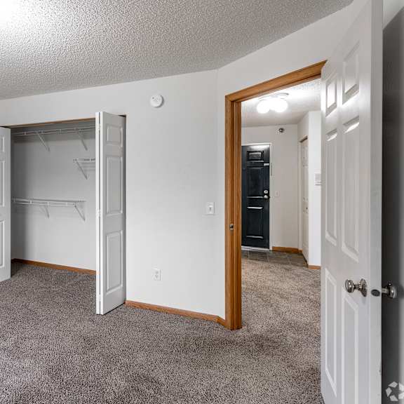 a room with a white door and a grey carpet.