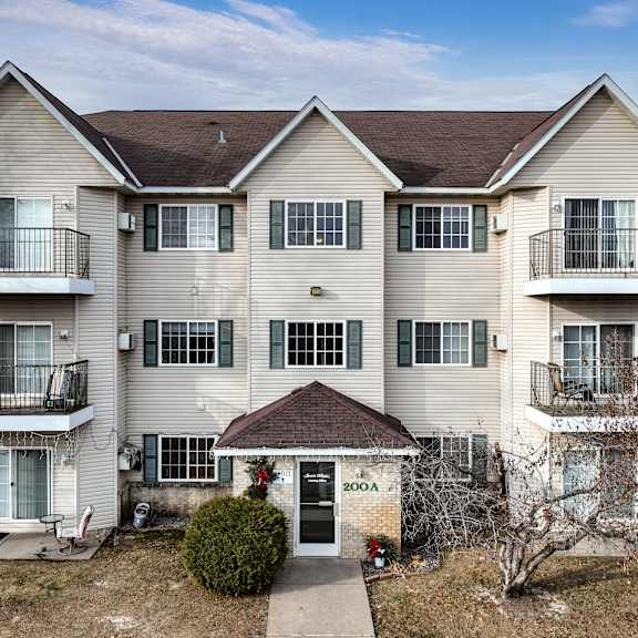 apartment building with balconies and a small entrance garden.