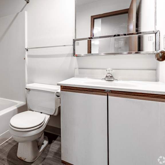 a white toilet sits in a bathroom next to a sink.