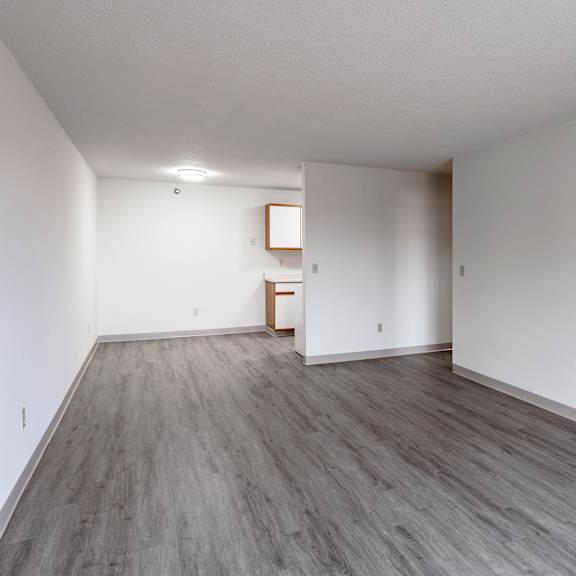 a room with wooden flooring and white walls.