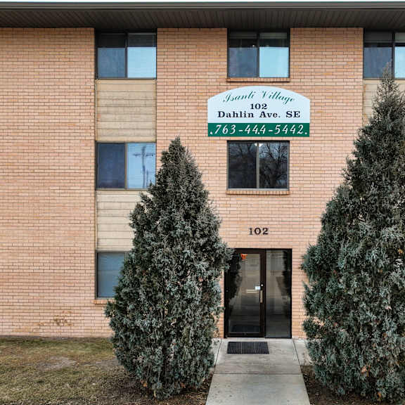the image shows the front of a building with a sign that reads "juniper village dahlin ave. se" and a phone number.