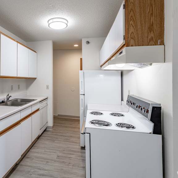 a kitchen with white appliances and wooden cabinets.