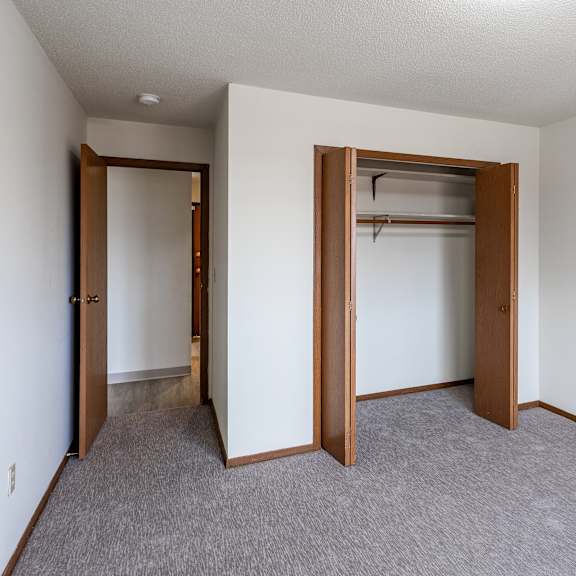 a room with a carpeted floor and two open doors.