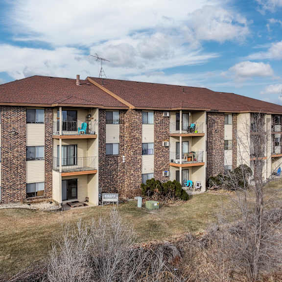 a large apartment complex with a grassy area in front.