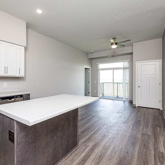 a kitchen with a white countertop and wooden cabinets.