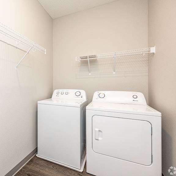 two white front loading washing machines in a laundry room.