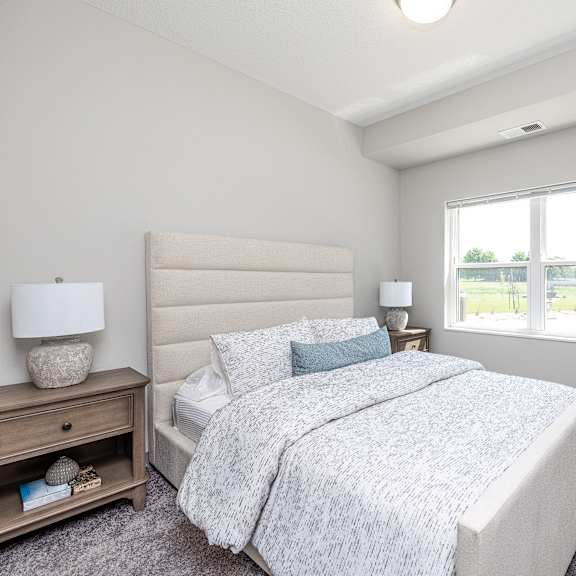 a bedroom with a large bed and a window overlooking a parking lot.