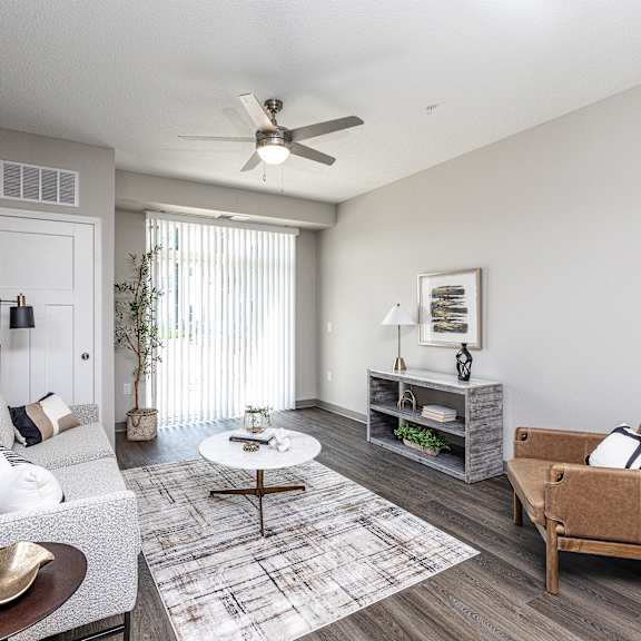 a living room with a grey couch, a coffee table, and a brown armchair.
