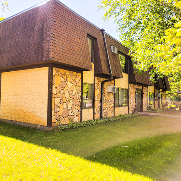 a house with a brown roof and stone walls.