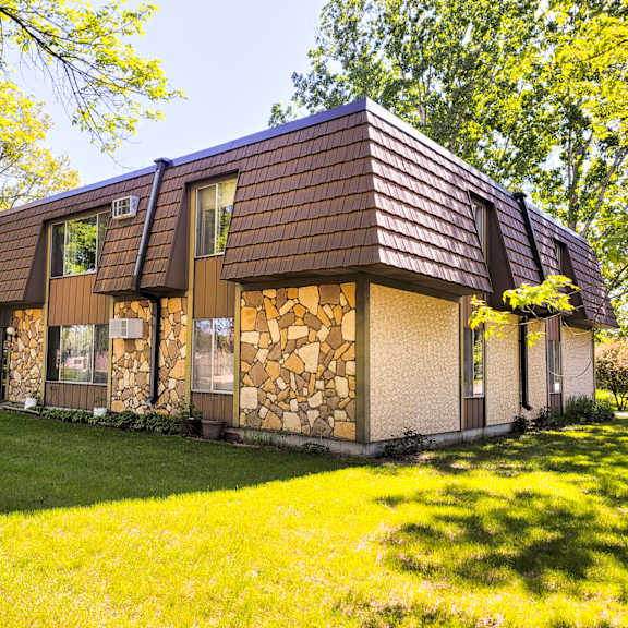 a house with a brown roof and stone walls.