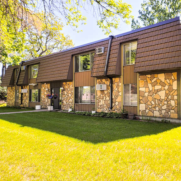 a house with a brown roof and stone walls.
