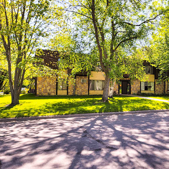 a house with a driveway and trees in front of it.