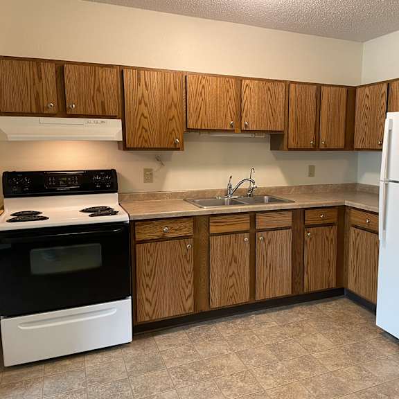 a kitchen with wooden cabinets and a white refrigerator.