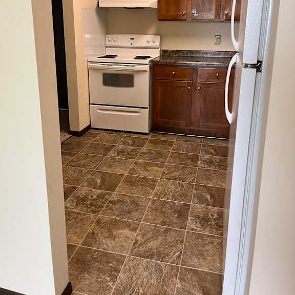 a kitchen with brown cabinets and a white countertop.
