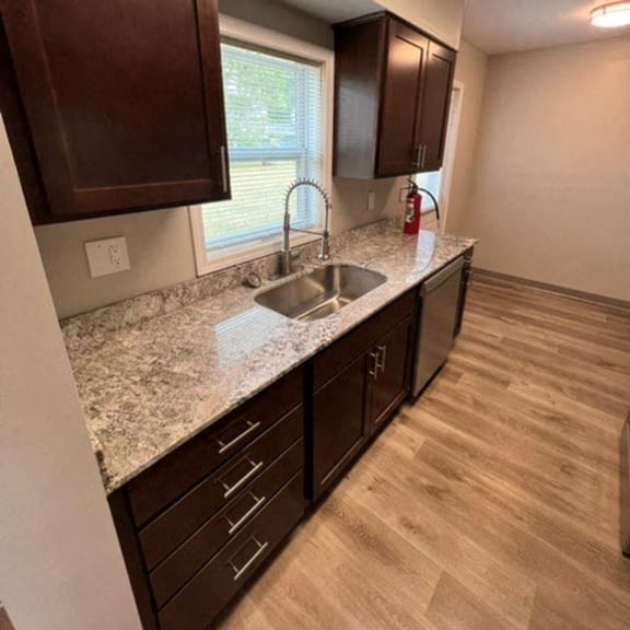 a kitchen with a sink and cabinets and a window