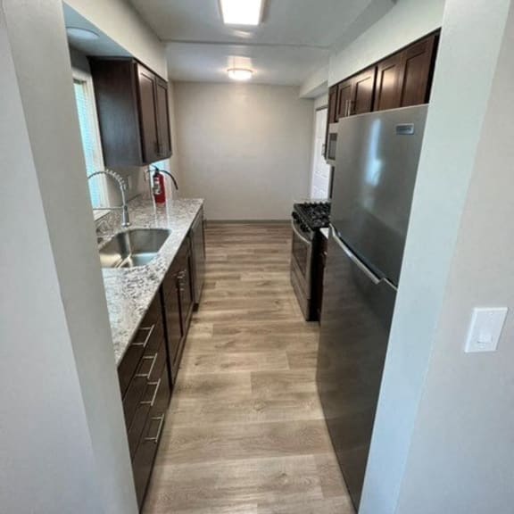 a kitchen with a stainless steel refrigerator and a sink