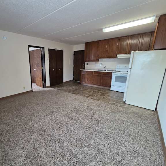 a kitchen area with a refrigerator, oven, and sink.