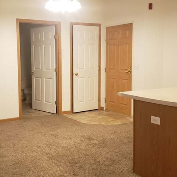 a room with a white counter top and a brown cabinet.