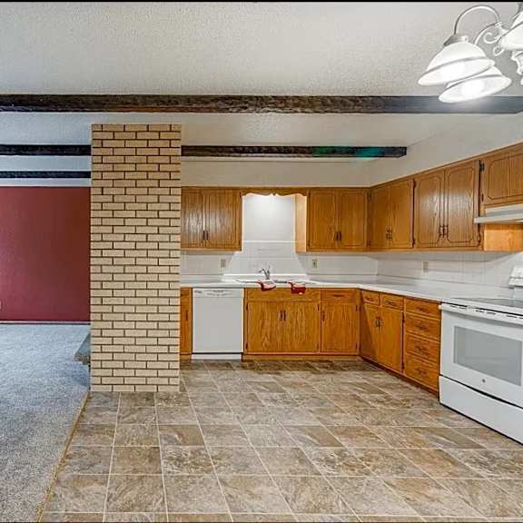 a kitchen with wooden cabinets and a tiled floor.