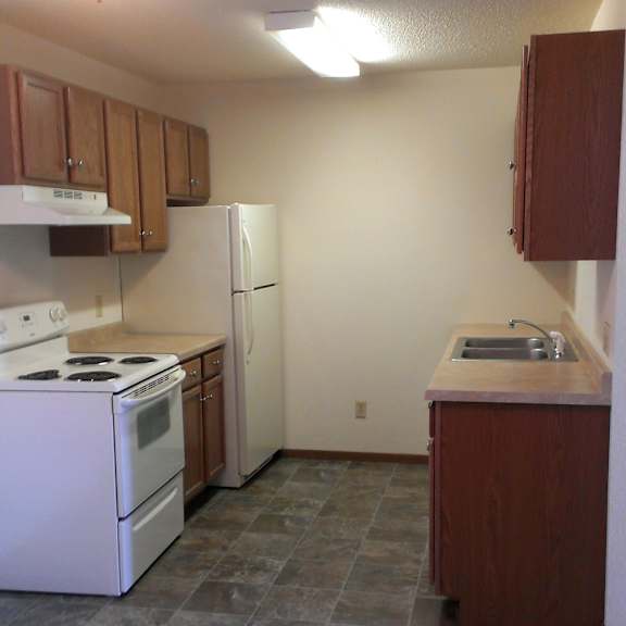 a kitchen with a white stove and white refrigerator.