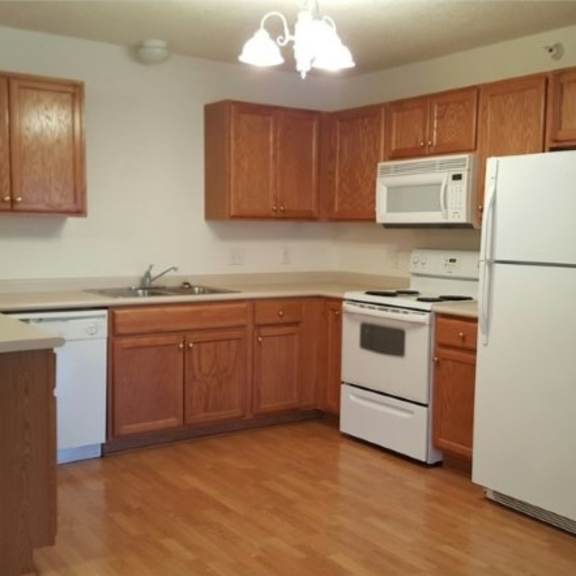 a kitchen with wooden cabinets and white appliances.
