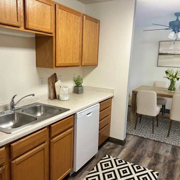 a kitchen with wooden cabinets and a white dishwasher.