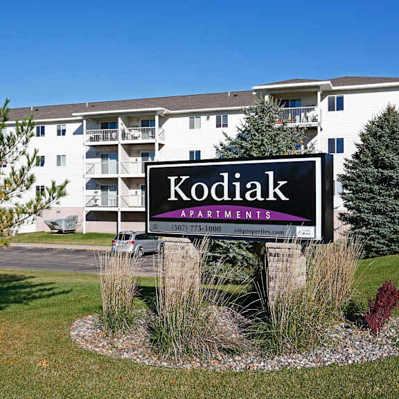 a sign for kodiak apartments in front of a building.