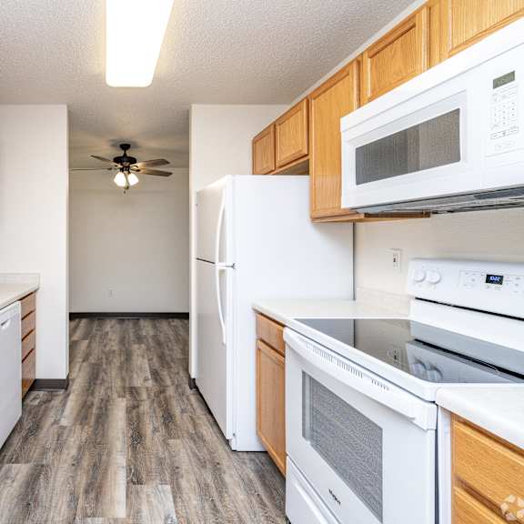 a kitchen with white appliances and wooden cabinets.