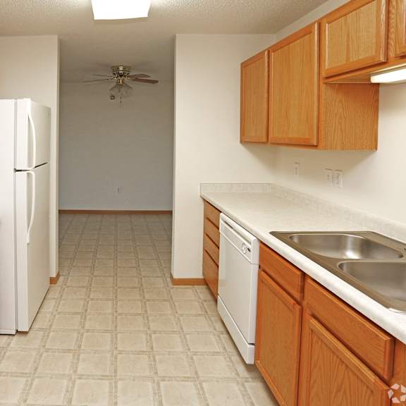a kitchen with white appliances and wooden cabinets.