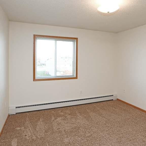 a room with a carpeted floor and a window.