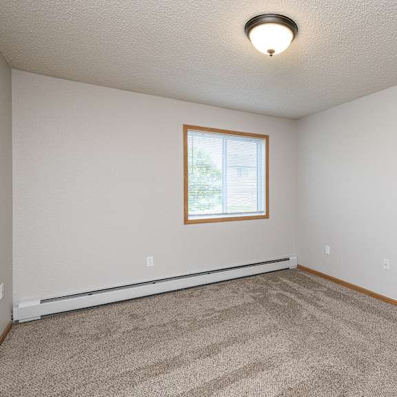 a room with a carpeted floor and a window.