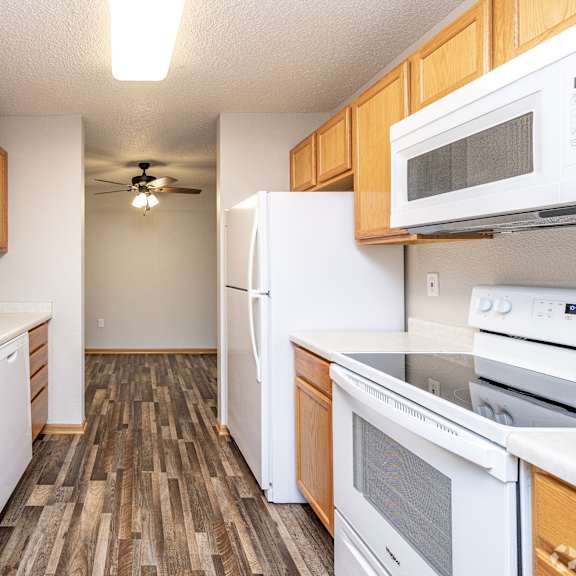 a kitchen with wooden cabinets and white appliances.