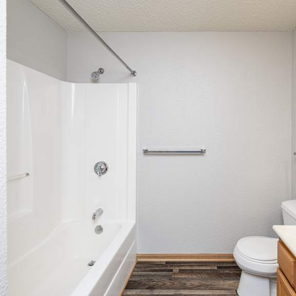 a white bathroom with a toilet, sink, and bathtub.