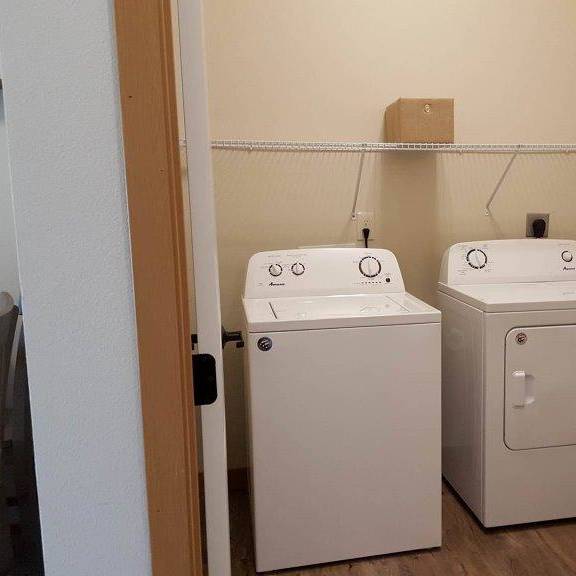 two white washing machines in a small room.