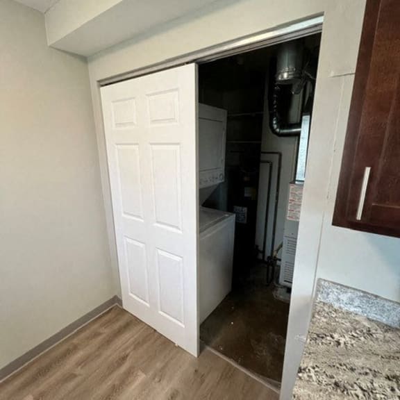 a closet with a white door and a wood floor