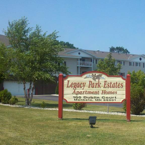 a sign for legacy park estates in front of apartment buildings.