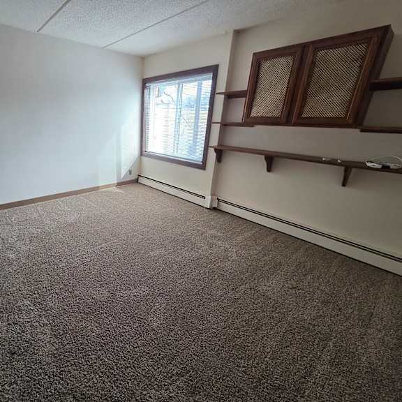 a room with a carpeted floor and a window.