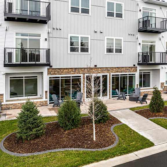 an exterior view of an apartment building with lawns and trees
