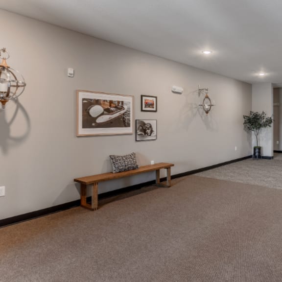 a room with a bench and pictures on the wall.