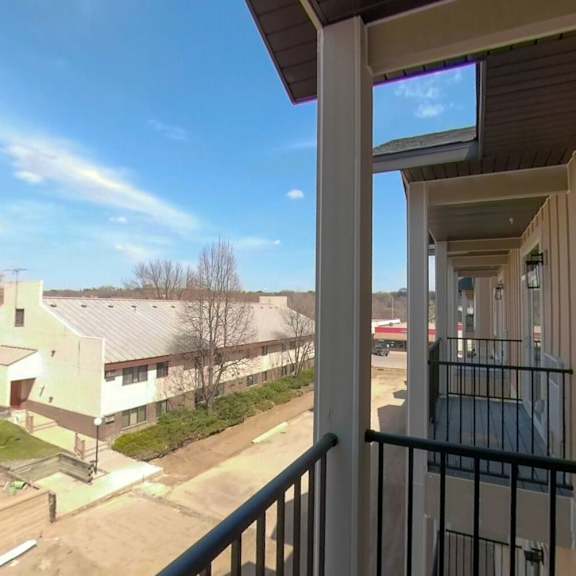 a balcony with a view of a building and a street